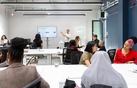 Students smiling and learning in a classroom at BrainStation London.